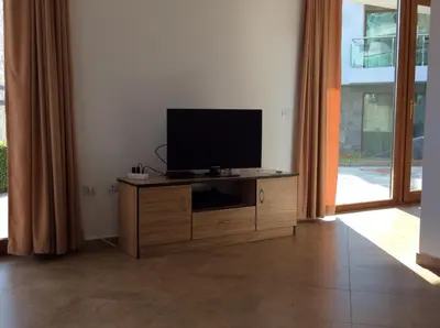 a television on a wooden cabinet in a living room at Seaside Apartment in Sozopol