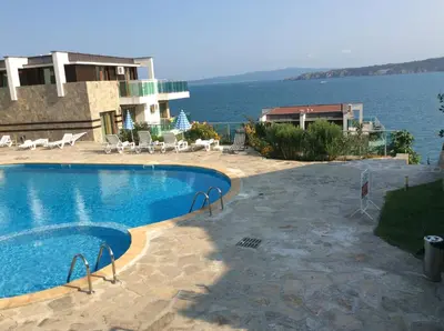 a swimming pool in front of a house with the water at Seaside Apartment in Sozopol