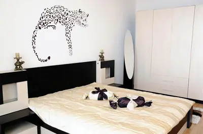 a bedroom with a bed with a giraffe on the wall at Sea Dream Rental Apartments in Varna City