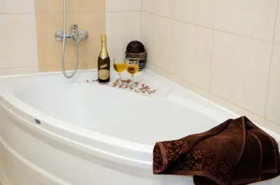 a bath tub with a bottle of wine and two glasses at Sea Dream Rental Apartments in Varna City