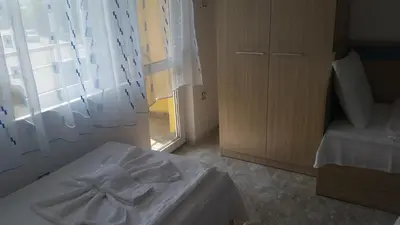 a room with a bed and a window with curtains at Blue House in Tsarevo
