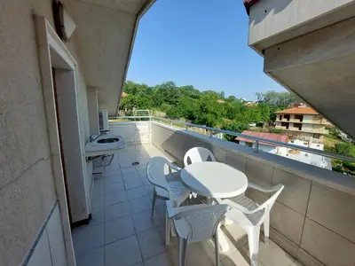 a balcony with a table and chairs and a sink at Fantastic Sea View Sun village Byala in Byala
