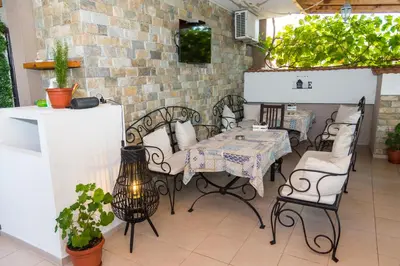 a patio with a table and chairs and a brick wall at Rodos House in Pomorie