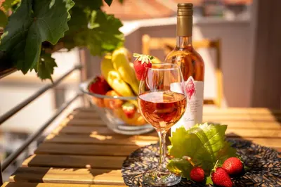 a glass of wine and a bowl of fruit on a table at Rodos House in Pomorie