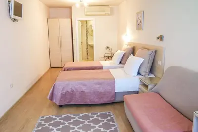 a hotel room with two beds and a couch at Hotel Acropolis in Varna City