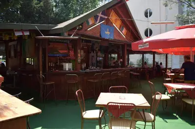 a restaurant with tables and chairs and a bar at Hotel Klisura in Sunny Beach