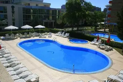 a large blue swimming pool with chairs and umbrellas at Hotel Klisura in Sunny Beach