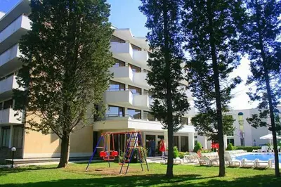 a apartment building with a playground in front of a building at Hotel Klisura in Sunny Beach