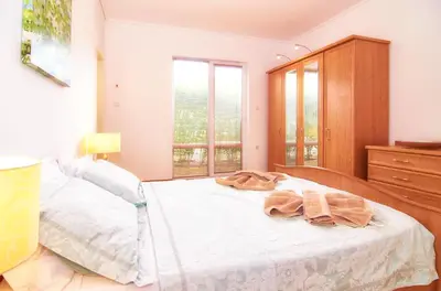 a bedroom with a bed and a dresser and windows at BulgariaVilla - Villa Knox in Bryastovets