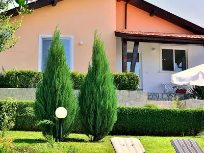 two cypress trees in front of a house at BulgariaVilla - Villa Knox in Bryastovets