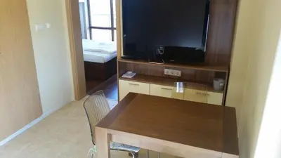 a living room with a table and a flat screen tv at Apartment in River Park in Sunny Beach