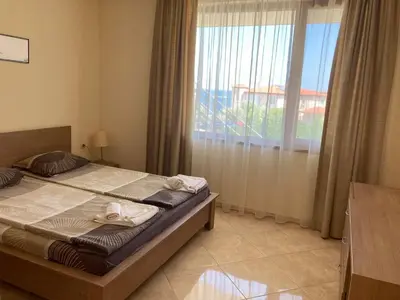 a bedroom with a bed and a large window at Apolon Complex in Sozopol