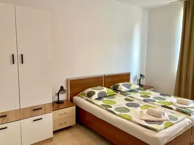 a bedroom with a large bed with a wooden headboard at Apolon Complex in Sozopol