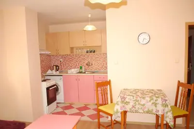 a kitchen with a table and chairs and a clock on the wall at CITY STAY in Varna in Varna City