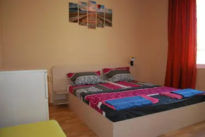 a bedroom with a bed with a red curtain at CITY STAY in Varna in Varna City