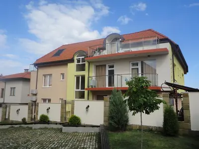 a yellow and white house with a fence at Barex Family Hotel in Sozopol