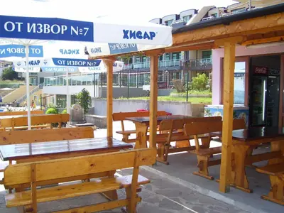 a group of tables and benches in front of a building at Barex Family Hotel in Sozopol