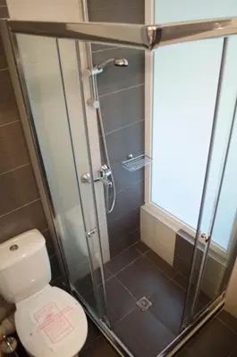 a shower stall in a bathroom with a toilet at Flagman Hotel in Sozopol