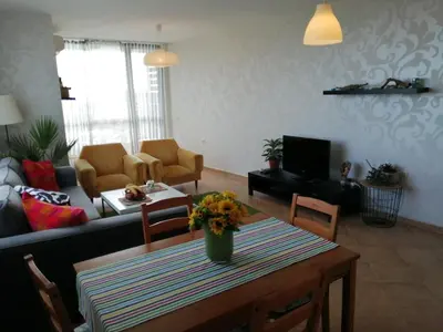 a living room with a table with flowers on it at Apartments Del Sol - Sunny Island Complex in Chernomorets