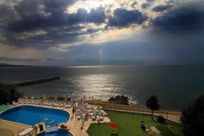 a view of a pool and the ocean with a rainbow at Peter Hotel in Ravda