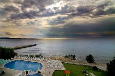 a view of a pool and chairs and the ocean at Peter Hotel in Ravda