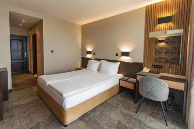 a hotel room with a bed and a desk at Kalithea Family Hotel in Sozopol