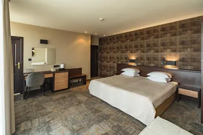 a hotel room with a bed and a desk at Kalithea Family Hotel in Sozopol