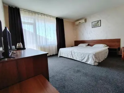 a hotel room with a bed and a desk at Sandor Hotel in Nesebar