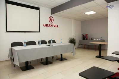 a conference room with a table and a projector screen at Gran Via in Burgas City