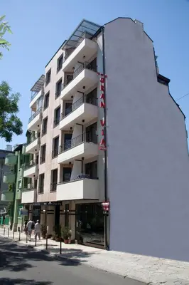 a tall white building on the side of a street at Gran Via in Burgas City