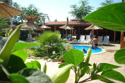a resort with a pool with people sitting in chairs at Family hotel Tropicana in Ravda