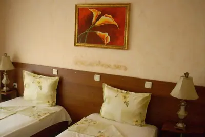 a hotel room with two beds and a painting on the wall at Family hotel Tropicana in Ravda