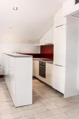 a white kitchen with white cabinets and a counter at Family Hotel Casa del Mare in Sozopol