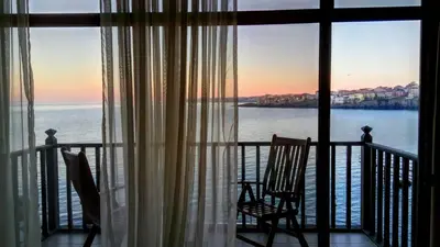 two chairs sitting on a balcony looking out at the water at Family Hotel Casa del Mare in Sozopol