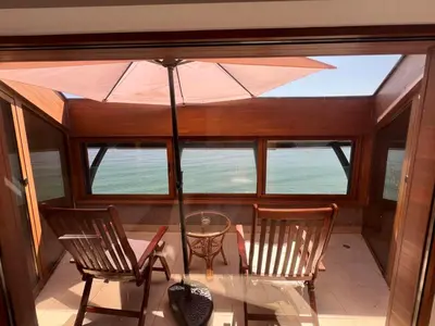 a balcony with two chairs and a table with an umbrella at Family Hotel Casa del Mare in Sozopol