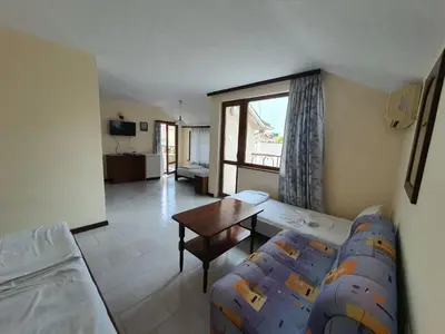 a room with two beds and a table in it at Lazur Hotel in Ravda