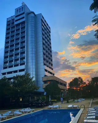 a tall building with a pool in front of a building at Kamenec Hotel in Nesebar