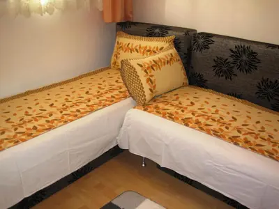 two beds sitting next to a couch in a room at Apartment Nadejda in Varna City