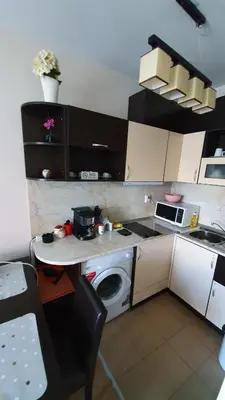 a kitchen with a washing machine and a microwave at апартамент CACAO RESIDENCE in Sunny Beach