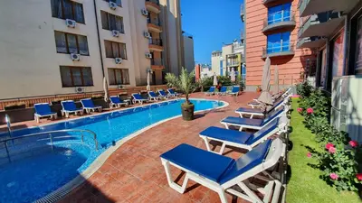 a hotel swimming pool with lounge chairs next to a building at апартамент CACAO RESIDENCE in Sunny Beach