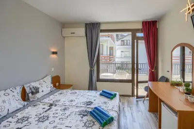 a bedroom with a bed and a desk and a window at Globus Kiten in Kiten