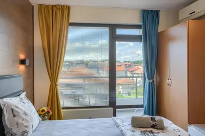 a bedroom with a bed and a large window at Globus Kiten in Kiten