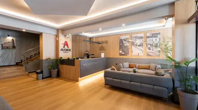 a lobby with a couch in front of a counter at Avenue Hotel in Burgas City