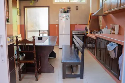 a kitchen with a table and a refrigerator at Marianas Guesthouse in Obzor