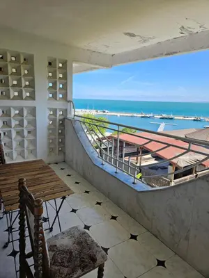 a balcony with a table and a view of the ocean at Lazur SeaView Apartment in Pomorie