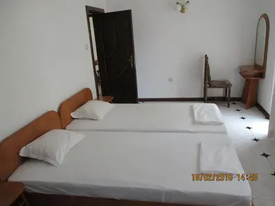 a bedroom with two beds and a chair at Lazur SeaView Apartment in Pomorie