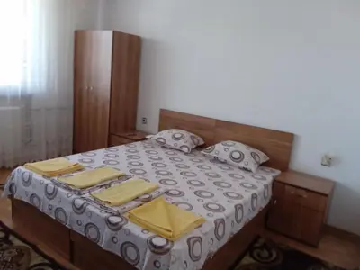 a bedroom with a bed with yellow napkins on it at Стаи за гости Петрови in Primorsko