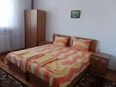 a bedroom with a bed with two pillows at Стаи за гости Петрови in Primorsko
