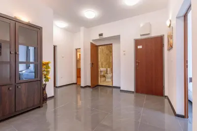 a hallway with wooden doors and tile floors at SeaSide Guest Rooms in Burgas City