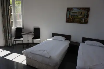 a bedroom with two beds and a table and chairs at SeaSide Guest Rooms in Burgas City